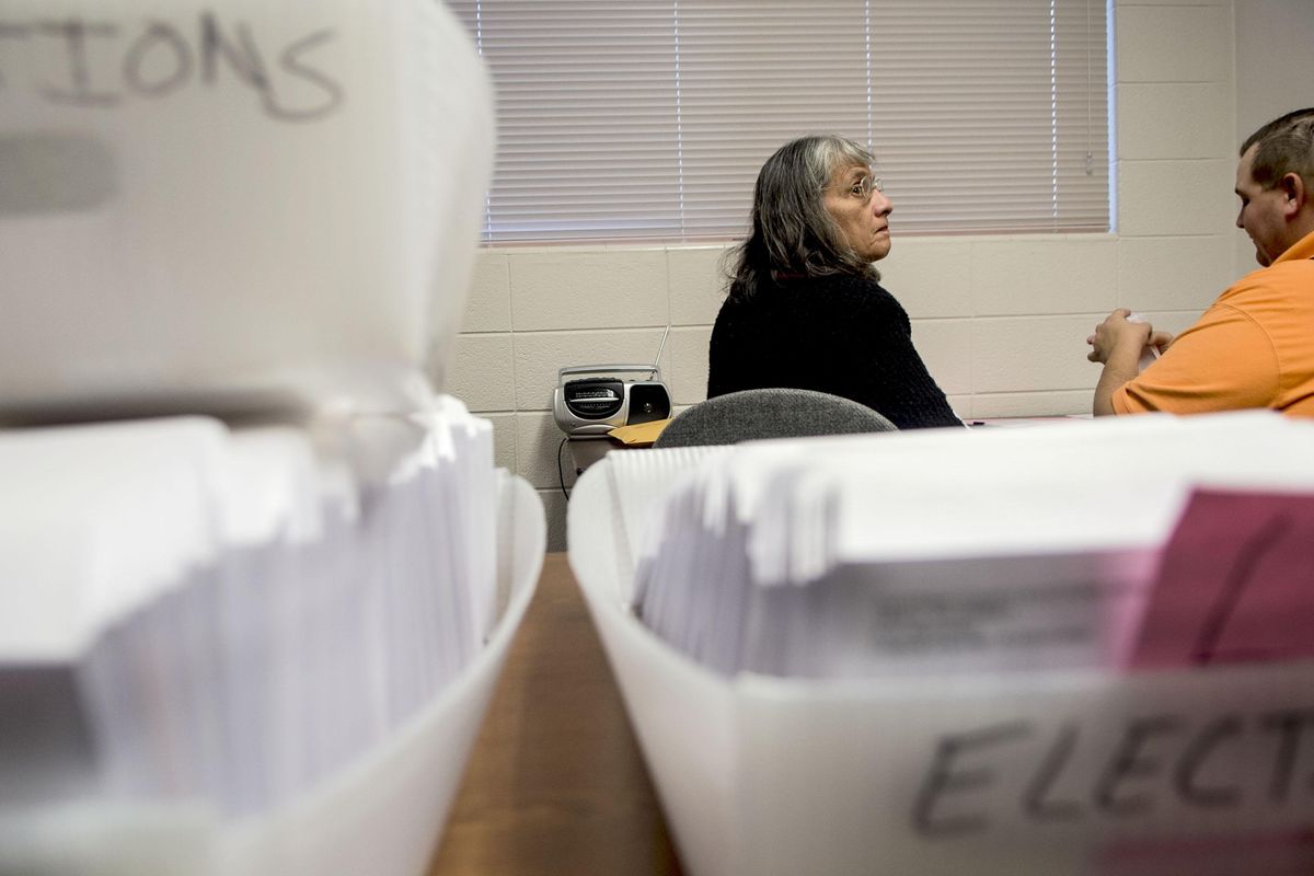 Temporary elections clerk Benita Castillo, left, waits for the count of absentee requests from fellow clerk Nick Cook at the Kootenai County elections office in Coeur d’Alene on Thursday, Oct. 6, 2016. (Kathy Plonka / The Spokesman-Review)