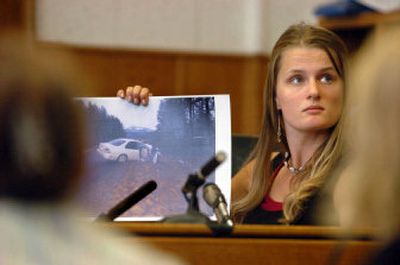 
Joleen Larsen, 18, holds a photo showing her sister's Honda, a car she was riding in, by a ditch after it was allegedly rammed by an SUV driven by Jonathan Ellington during a confrontation in which he allegedly ran over and killed Larsen's mother, Vonette. 
 (Jesse Tinsley / The Spokesman-Review)
