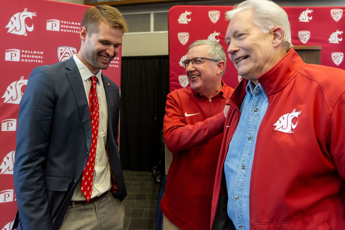 Washington State University head men's basketball David Riley, left, talks with President Kirk Schulz, center and Glenn Johnson on Thursday, April 4, 2024, after a press conference at Gesa Field in Pullman. Johnson is a former mayor or Pullman, retired WSU professor and is the announcer for the men's basketball games.  (Geoff Crimmins/For The Spokesman-Review)