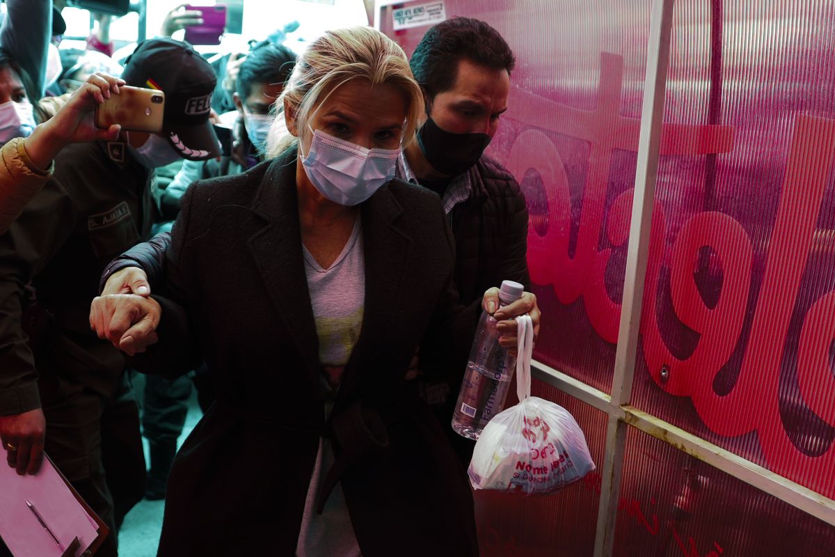 Bolivia’s former interim President Jeanine Anez is escorted into a police station after giving her statement at the prosectors’s office, in La Paz, Bolivia, Saturday, March 13, 2021. The conservative interim president who led Bolivia for a year was arrested Saturday as officials of the restored leftist government pursue those involved in the 2019 ouster of socialist leader Evo Morales, which they regard as a coup, and the administration that followed.  (Juan Karita)