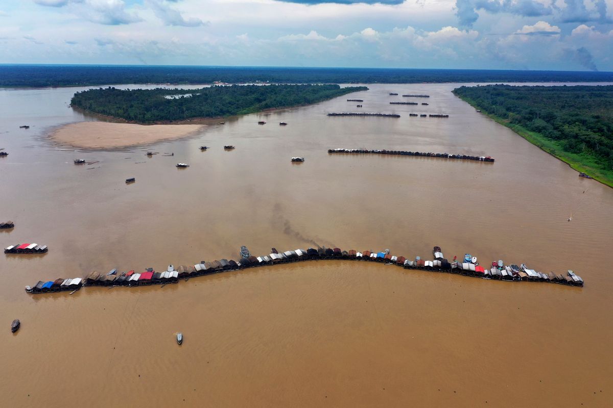 Dredging barges operated by illegal miners converge on the Madeira river, a tributary of the Amazon river, searching for gold, in Autazes, Amazonas state, Brazil, Thursday, Nov.25, 2021. Hundreds of mining barges have arrived during the past two weeks after rumors of gold spread, with environmentalists sounding the alarm about the unprecedented convergence of boats in the sensitive ecosystem.  (Edmar Barros)