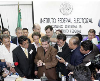 
Mexican electoral official Andres Perez records the time of arrival of a legal document from the Democratic Revolution Party at a polling station in Mexico City on Sunday. The PRD  made the midnight deadline by minutes. 
 (Associated Press / The Spokesman-Review)