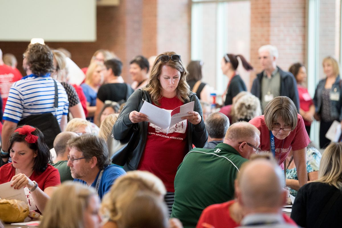 Lindsey Pugh, a teacher at Shadle Park High School, reads through a packet of materials before a ratification vote on the proposed contract between the Spokane Education Association and Spokane Public Schools on Thursday, Aug. 30, 2018, at Shadle Park High School in Spokane, Wash. (Tyler Tjomsland / The Spokesman-Review)