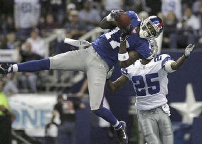 
Giants wide receiver Plaxico Burress pulls in a 50-yard touchdown pass in front of Cowboys safety Patrick Watkins.
 (Associated Press / The Spokesman-Review)