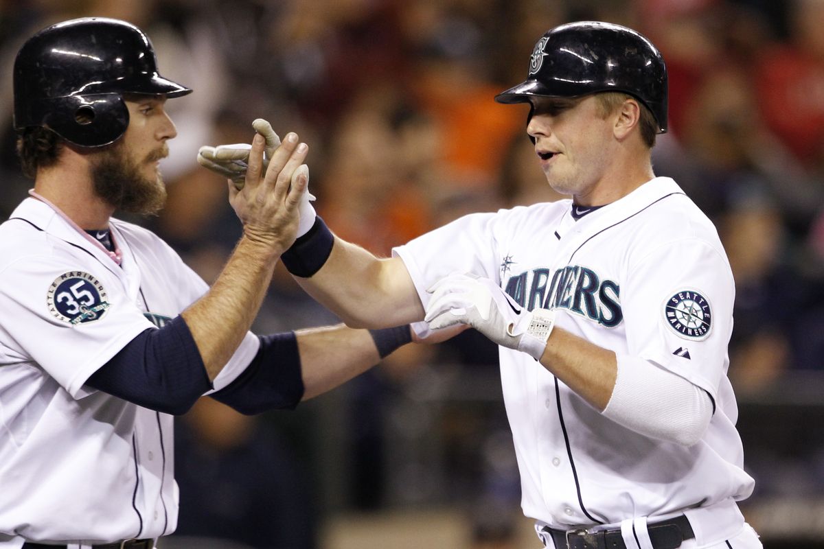 John Jaso, left, greets Kyle Seager at home plate. Seager became the first M’s batter to hit 20 home runs in a season since 2009 on Tuesday. (Associated Press)
