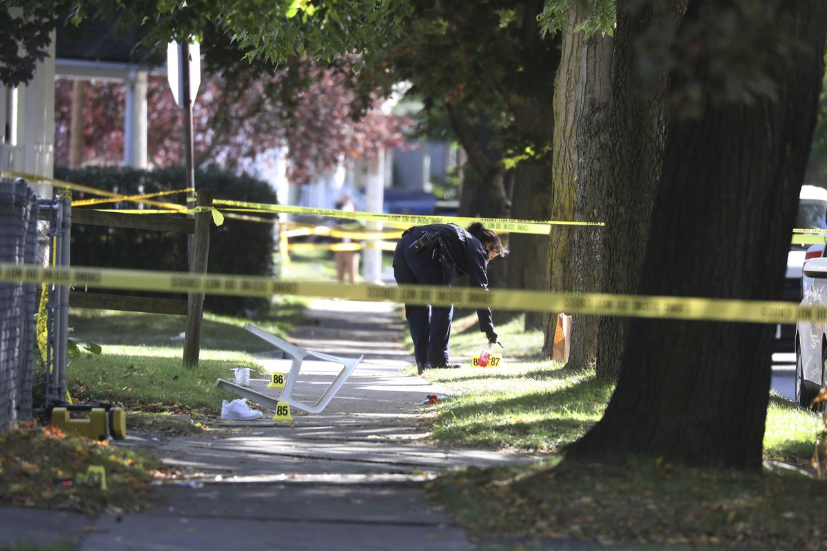 A Rochester police technician picks up some items as evidence near the home where a fatal house party took place Saturday in Rochester, N.Y.  (Tina MacIntyre-Yee)