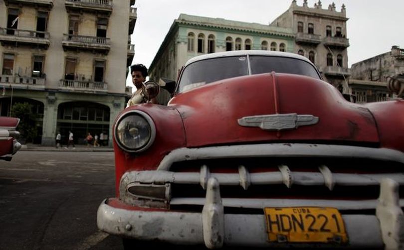 AP Photo/Javier Galeano

A woman leans against an old car, used as a taxi, in Havana, Friday. Cuba's government has begun the distribution of permits to legalize old cars, currently used as black-market taxis. (The Spokesman-Review)