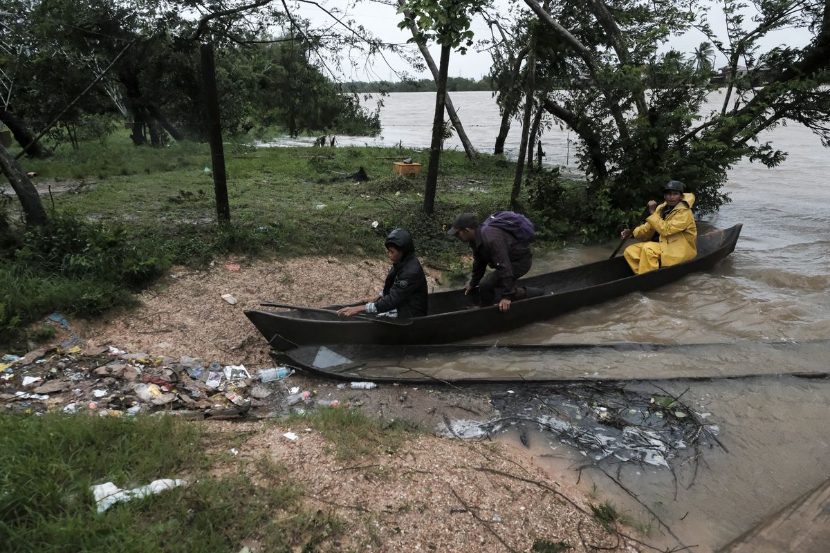 People arrive in a boat to Wawa in Wawa, Nicaragua, Tuesday, Nov. 3, 2020. Hurricane Eta slammed into Nicaragua