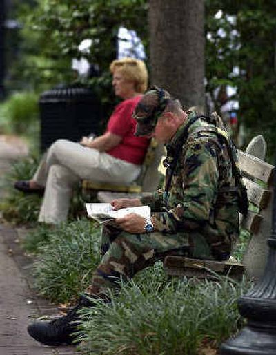 
A Georgia National Guardsman reads a local newspaper Monday while sitting on a bench in a park in Savannah, Ga. 
 (Associated Press / The Spokesman-Review)