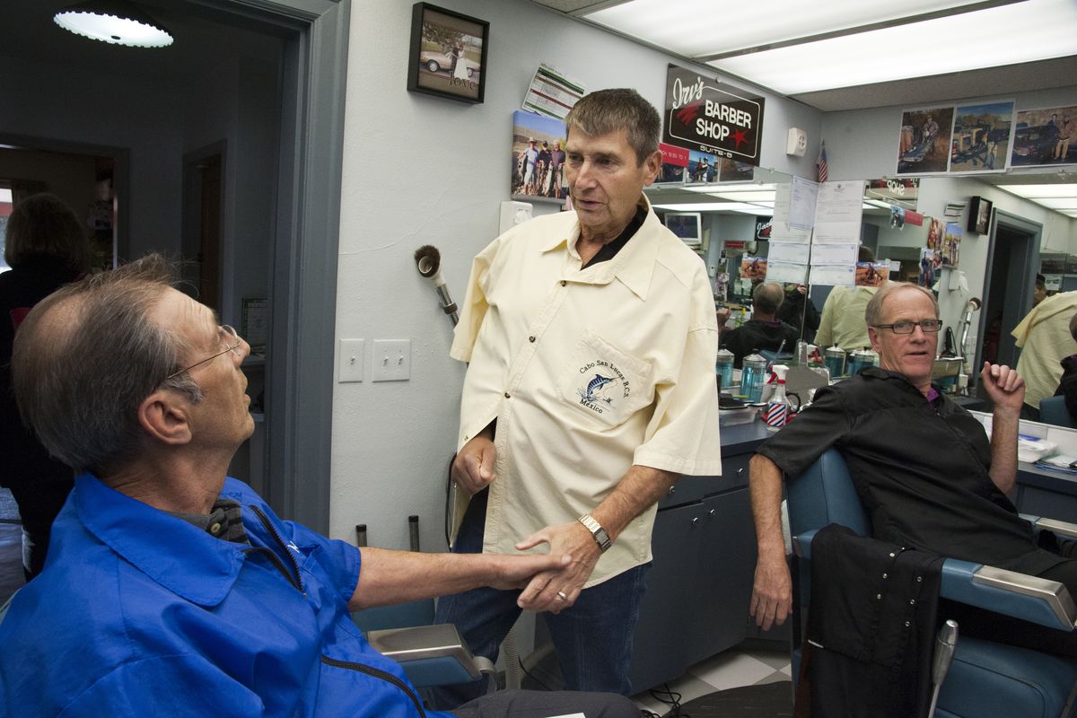 Tom Groh says goodbye to barber Mike LaBella, left, after a visit to Tom’s Barber Shop on April 8. After 49 years in business at the Spokane Valley shop, Groh is laying down his scissors. He’s turning the business over to his nephew, Irv Groh, at right. (Dan Pelle)