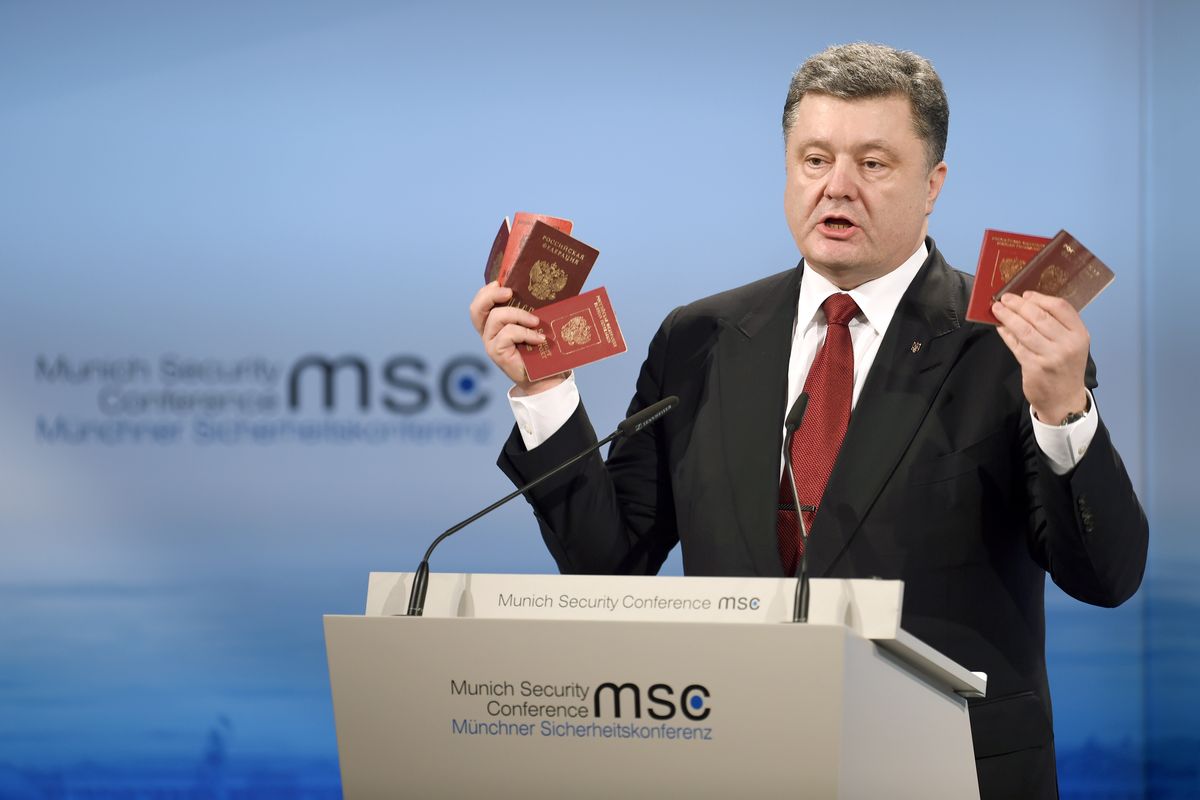 Ukraine’s President Petro Poroshenko holds Russian passports he says are proof of the presence of Russian troops in Ukraine as he addresses the Security Conference in Munich, Germany, on Saturday. (Associated Press)