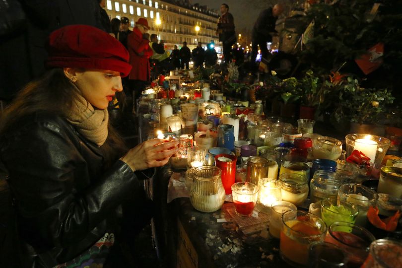       Mastioucha Peres, 30, from Paris, lights candles during a gathering that marks one year after the attacks on Charlie Hebdo in Paris on Thursday.   (AP)