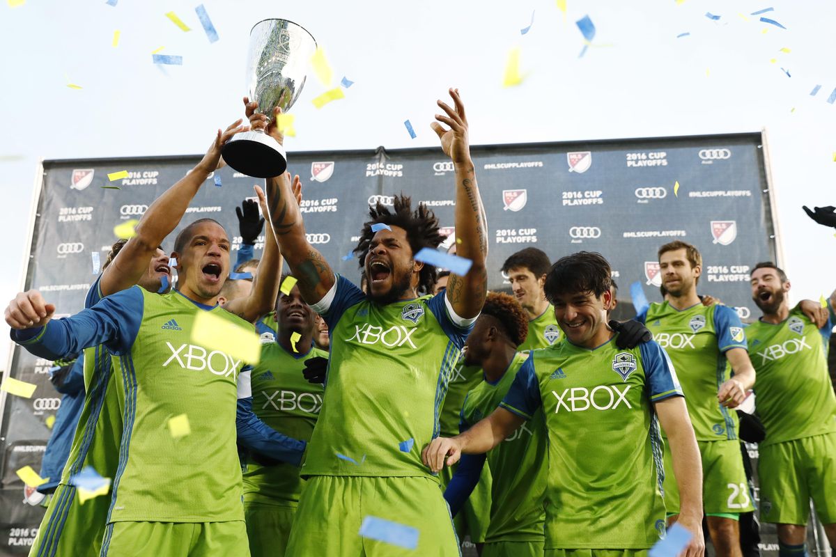 From left to right, Seattle Sounders midfielder Osvaldo Alonso, defender Roman Torres and midfielder Nicolas Lodeiro celebrate with teammates after being awarded the trophy for defeating Colorado in the second half of the second leg of the MLS Western Conference soccer finals Sunday, Nov. 27, 2016, in Commerce City, Colo. (David Zalubowski / Associated Press)