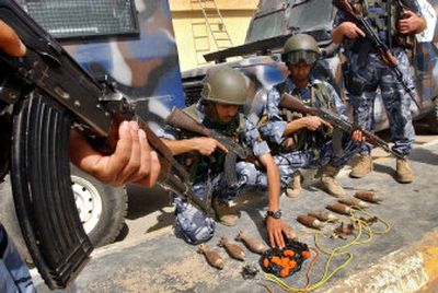 
Iraqi policemen display ammunition recovered during a raid in Basra, Iraq, on Monday. 
 (Associated Press / The Spokesman-Review)
