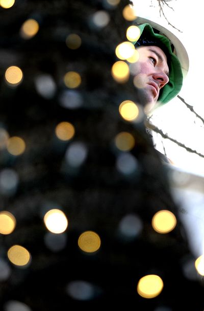 Spreading good cheer: Preston Hill of the city of Post Falls Parks Department strings lights on the trees near Post Falls City Hall on Monday to get the city in the spirit of the holiday season. (Kathy Plonka)
