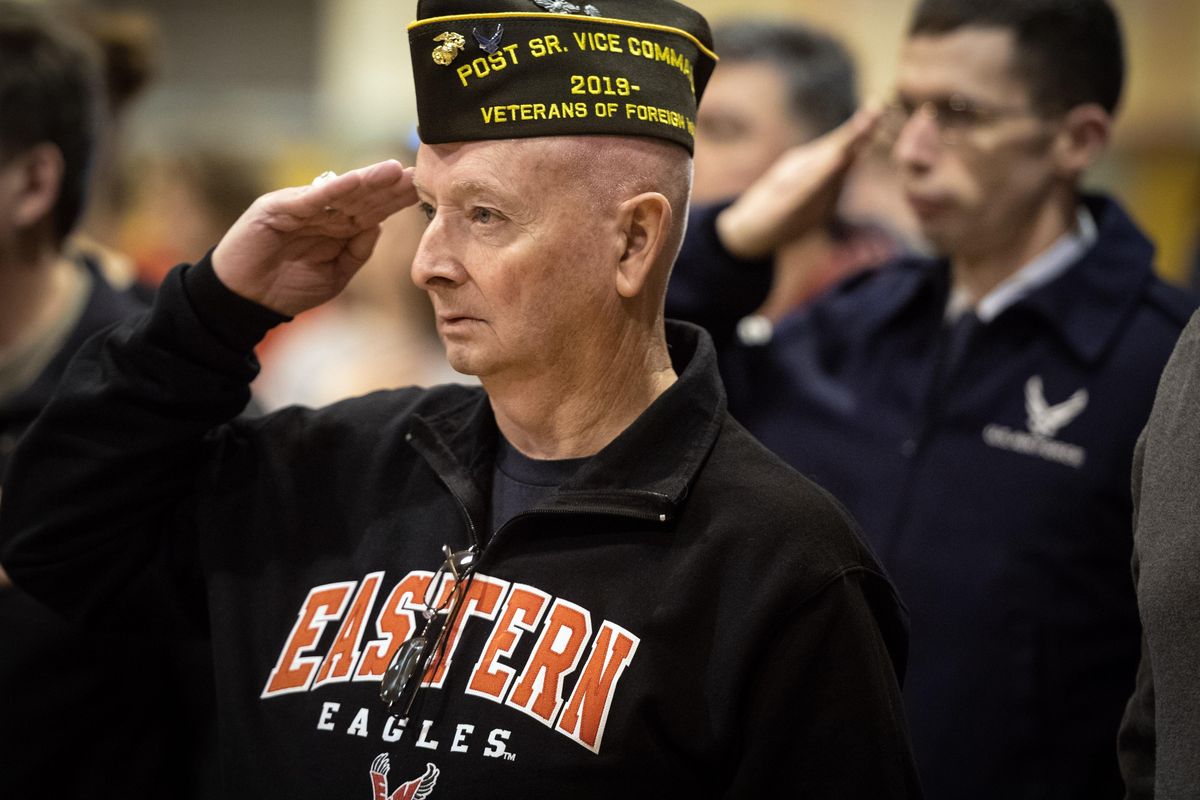 Tom Pauley, U. S. Marines and U.S Air Force veteran, left, and Jerry Harrison, U.S Air Force and currently at Fairchild Air Force Base, right, honor America during the Sacajawea Middle School’s Veterans Day  tribute, Friday, Nov. 8, 2019. (Dan Pelle / The Spokesman-Review)