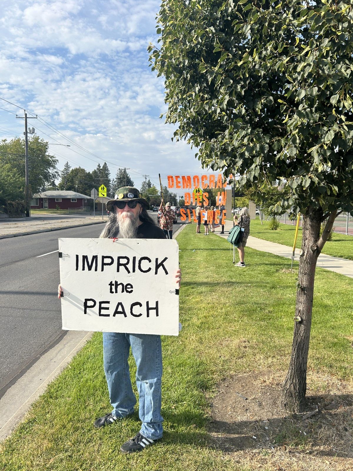 Brian Brown holds a sign at the Freedom Friday event for KSPS outside the KSPS PBS building in Spokane on Aug. 1. (Mathew Callaghan/The Spokesman-Review)