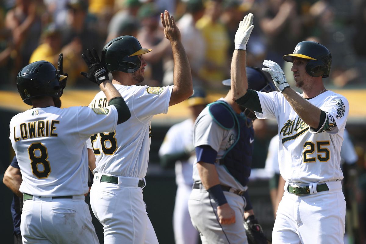 Oakland Athletics’ Stephen Piscotty, right, celebrates with Matt Olson (28) and Jed Lowrie (8) after hitting a three-run home run against the Seattle Mariners during the eighth inning of a baseball game Sunday, Sept. 2, 2018, in Oakland, Calif. (Ben Margot / Associated Press)