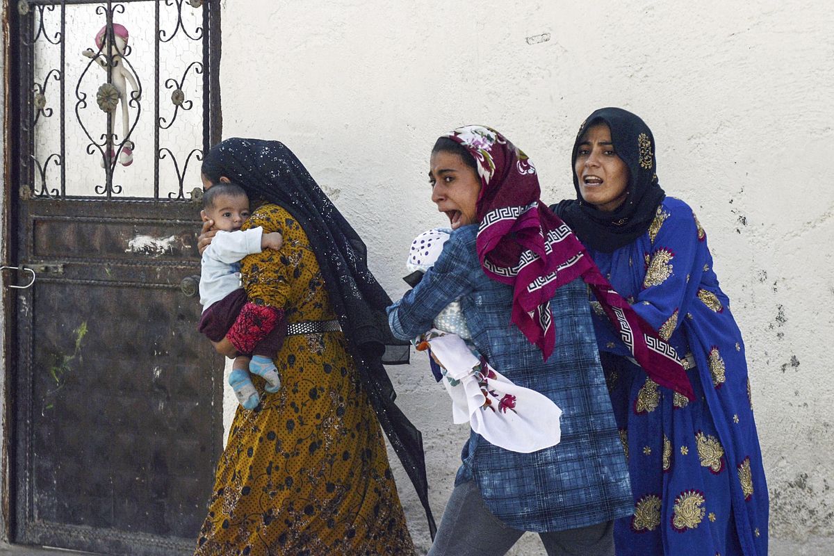 People run to take cover after mortars fired from Syria hit Akcakale, Turkey, on Thursday, Oct. 10, 2019. On Friday, Turkish forces faced fierce resistance from U.S.-allied Syrian Kurdish fighters on the third day of Ankara’s offensive in northern Syria, as casualties mounted, international criticism of the campaign intensified and estimates put the number of those who fled the violence at 100,000. (Ismail Coskun / Associated Press)