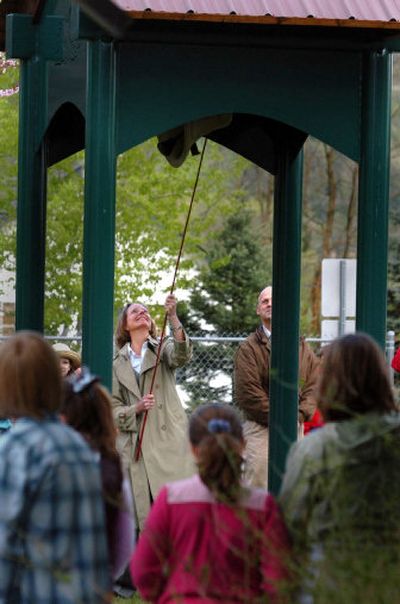 
As students and parents watch, Principal Kathy Liverman uses a rod to ring the school bell at Dalton Elementary  May 4. The bell is the original one from the school, and has been returned to the school grounds.
 (Jesse Tinsley / The Spokesman-Review)