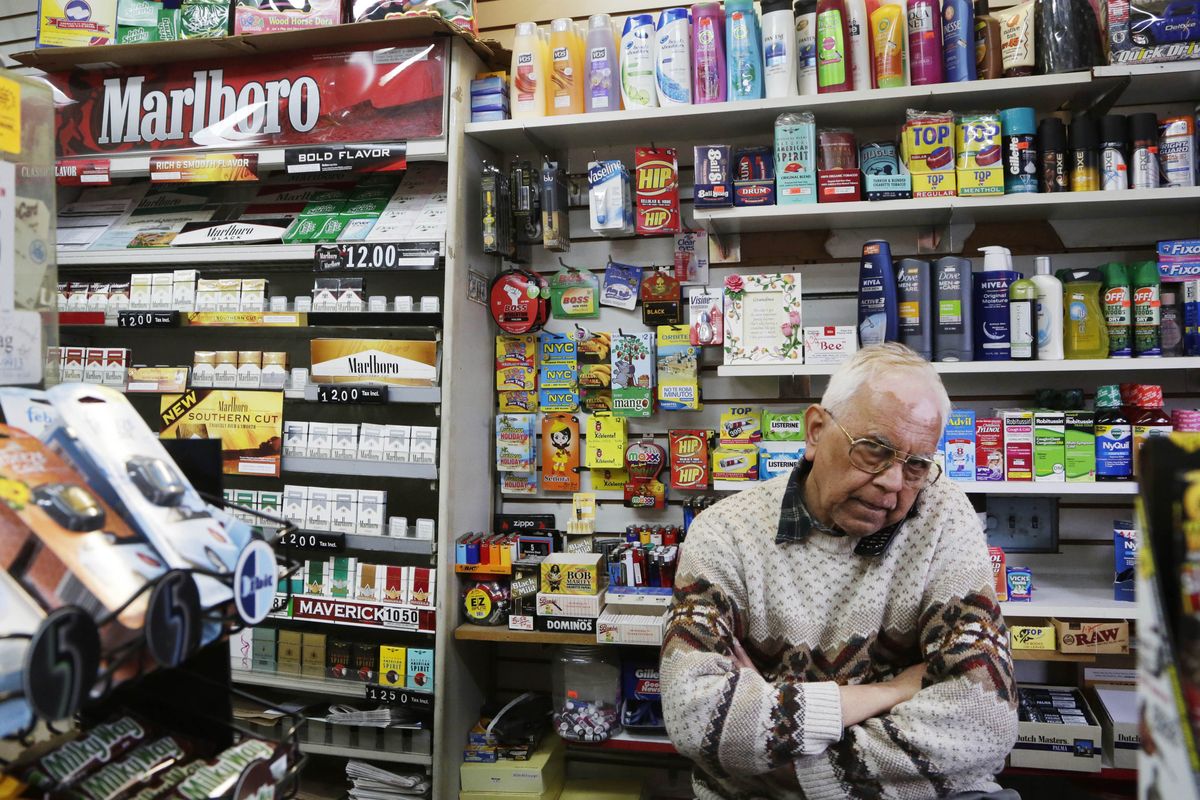 Harry Patel, an employee of Blondie’s Deli and Grocery, talks on the phone while waiting for customers in New York on Monday. A new anti-smoking proposal would make New York the first city in the nation to keep tobacco products out of sight in retail stores. (Associated Press)