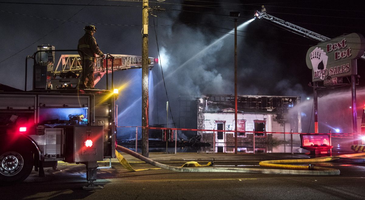 Spokane Valley Fire Department firefighters pour water down on a blaze at the Best Bet Auto Sales building and surrounding properties Wednesday morning, Oct. 18, 2017, at 4605 E. Sprague Avenue in Spokane Valley, Wash. (Dan Pelle / The Spokesman-Review)