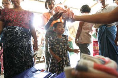 
A young survivor of Cyclone Nargis watches as her companion receives free clothing donated by local donors at a monastery in the outskirts of Yangon, Myanmar, on Saturday. Associated Press
 (Associated Press / The Spokesman-Review)