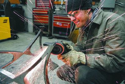 
 Biggs grinds on a dinning room table in his workshop.
 (The Spokesman-Review)