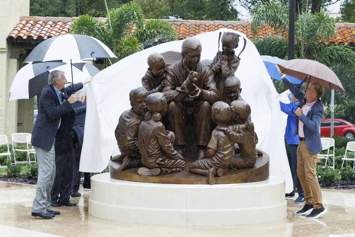 Rollins College school officials unveil a sculpture honoring alumnus and beloved children’s TV host Mister Rogers on Thursday in Winter Park, Fla. (Scott Cook)