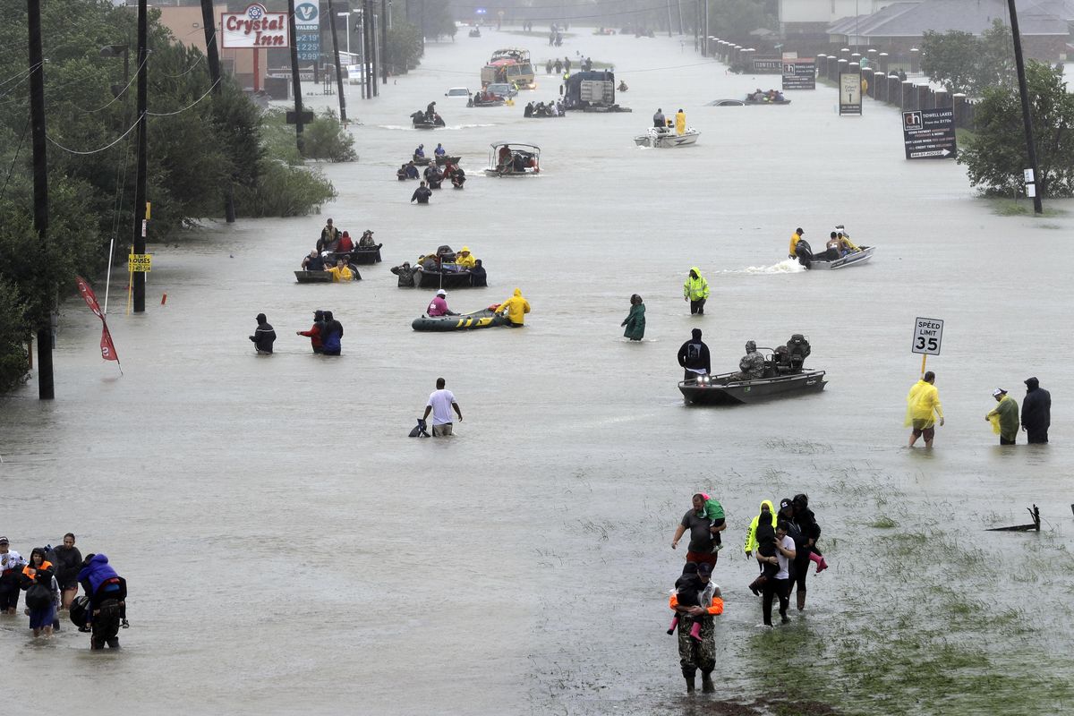 Rescue boats fill a flooded street at flood victims are evacuated as floodwaters from Tropical Storm Harvey rise Monday, Aug. 28, 2017, in Houston. (David J. Phillip / Associated Press)