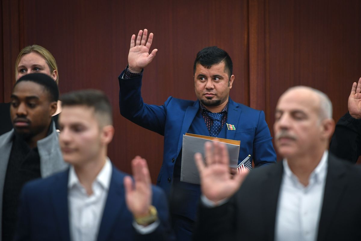 Baidar Hammad, a former interpreter for U.S. Special Forces in Afghanistan, raises his hand to become a U.S. citizen on Nov. 12, 2019, at the Thomas Foley United States Courthouse in downtown Spokane.  (DAN PELLE/The Spokesman-Review)