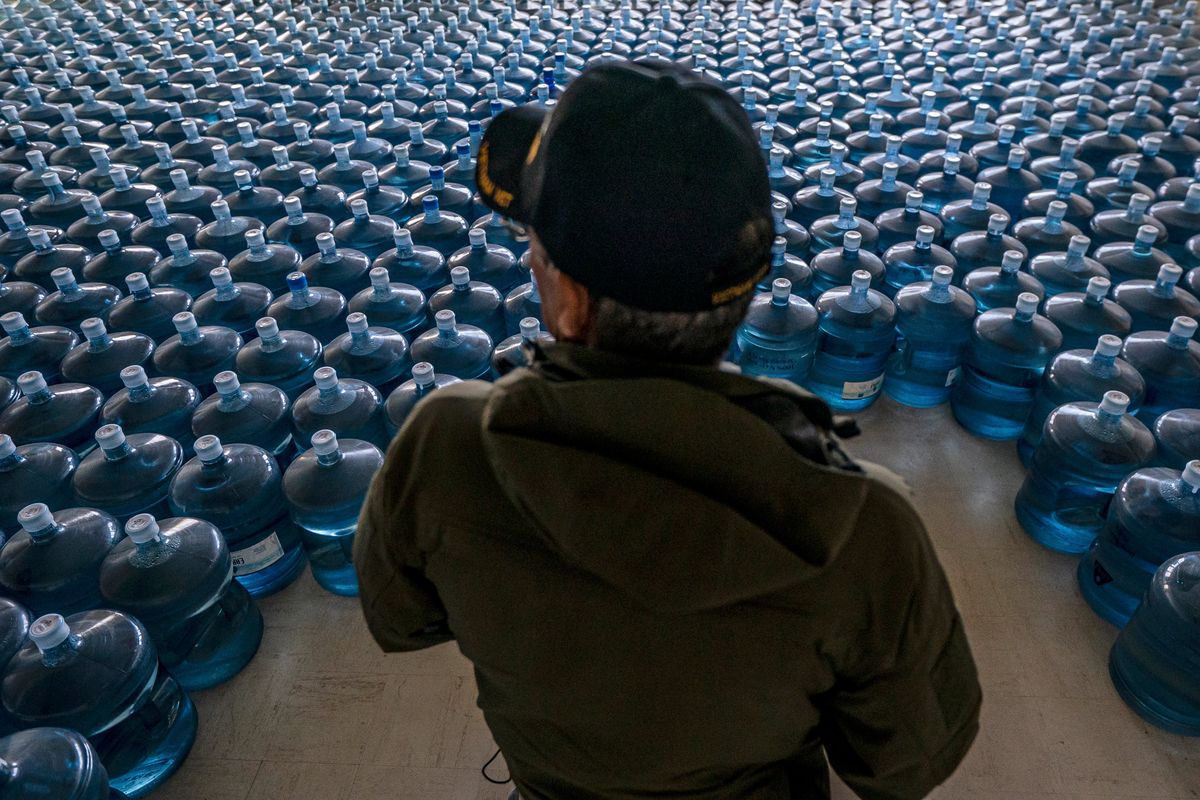Dan Martinez, emergency manager for the Confederated Tribes of Warm Springs, pauses in a classroom used to store donated water on Tuesday, Dec. 7, 2021, in, Warm Springs, Ore. In Oregon, tribal officials have handed out about 3 million gallons (11 million liters) of water — almost all of it donated — from a decommissioned elementary school on the reservation. (Nathan Howard)