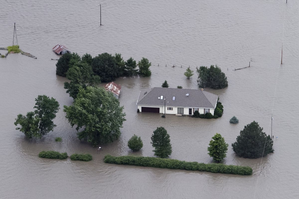 A home is engulfed by floodwaters in Hamburg, Iowa, on Monday. The rising Missouri River has ruptured two levees in northwest Missouri, sending torrents over rural farmland in Iowa and the Missouri resort town of Big Lake. (Associated Press)