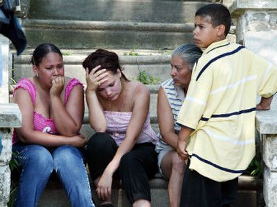 
From left to right, Marilyn Cheverez, Mariana Cheverez, Carmen Esperanza and Benjamin Agosto, 12, gather Saturday near the homes of three children who were found dead in a trunk on Friday in Camden, N.J. 
 (Associated Press / The Spokesman-Review)