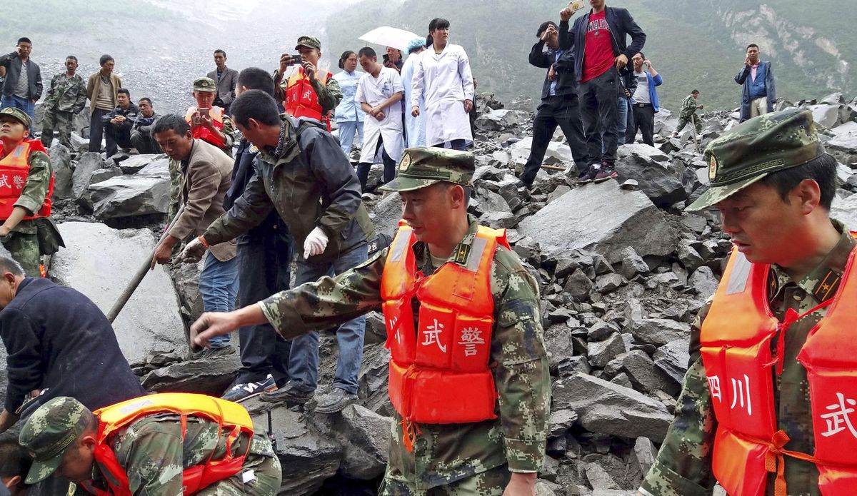 Emergency personnel and local people work at the site of a landslide in Xinmo village in Maoxian County in southwestern China’s Sichuan Province, Saturday, June 24, 2017. Dozens of people are feared buried by a landslide that unleashed huge rocks and a mass of earth that crashed into their homes in southwestern China early Saturday, a county government said. (Chinatopix)