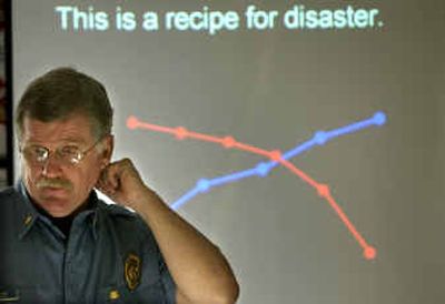 
Fire Lt.  Greg Borg answers questions in front of a slide presentation depicting the rising volume of emergencies and falling number of firefighters at a press conference Wednesday morning. 
 (Holly Pickett / The Spokesman-Review)