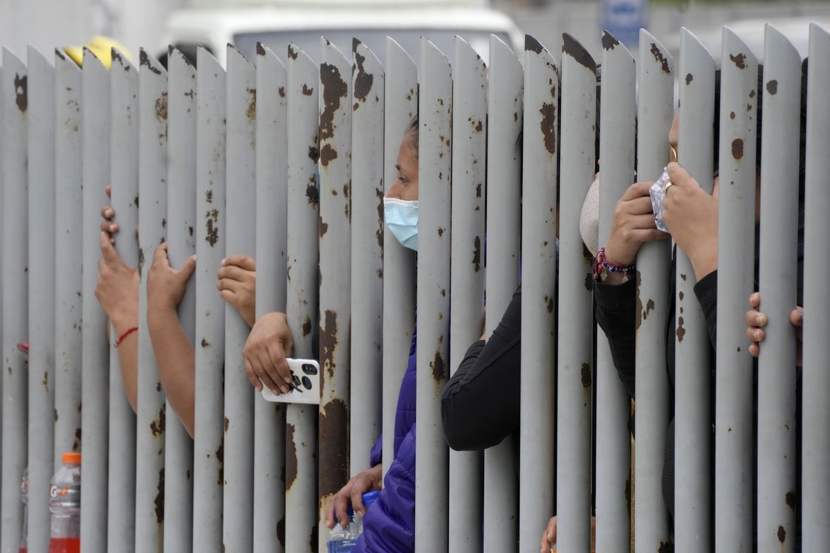 Relatives wait outside the morgue for news on their relatives who were inmates at the Litoral penitentiary, after deadly riots broke out inside the prison in Guayaquil, Ecuador, Sunday, Nov. 14, 2021.  (Dolores Ochoa)