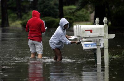 
Shaniqua Greene, right, and Tiffany Ward check the mail in their flooded neighborhood in Wilmington, N.C., on Thursday, after Tropical Storm Ernesto dumped heavy rains in the area.
 (Associated Press / The Spokesman-Review)