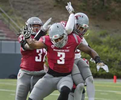 Washington State’s Sulaiman Hameed (37) and Ivan McLennan (3) celebrate with Charleston White, right, after White’s interception. (Dan Pelle)