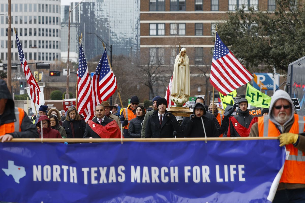 Protesters walk along Jackson St. during the North Texas March for Life, celebrating the passage and court rulings upholding the Texas law known as Senate Bill 8, on Saturday, Jan. 15, 2022, in Dallas. Abortions in Texas fell by 60% in the first month under the most restrictive abortion law in the U.S. in decades. That