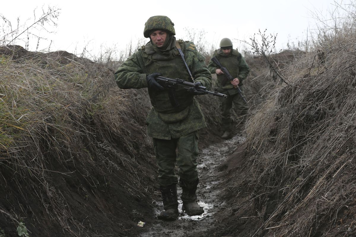 Serviceman walk in a trench at the line of separation near Sentianivka, Luhansk region, controlled by Russia-backed separatists, eastern Ukraine, Thursday, Dec. 9, 2021. Russia