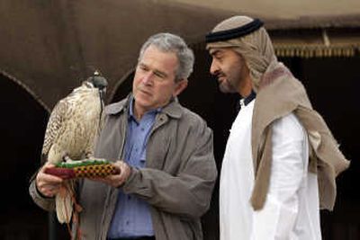 
President  Bush holds a falcon as the crown prince of Abu Dhabi, Sheik Mohammed bin Zayed Al Nahyan, watches Sunday at  the Royal Stables at the Al Asayl Racing and Equestrian Club near the town of Sowaihan in United Arab Emirates. Associated Press
 (Associated Press / The Spokesman-Review)