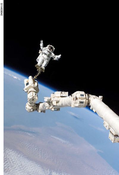 
This image released by NASA Saturday shows Stephen Robinson, STS-114 mission specialist, anchored to a foot restraint Wednesday on the space station's Canadarm2.
 (Associated Press / The Spokesman-Review)