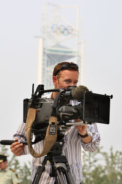 A television cameraman works on the Olympic Green, near the Ling Long Tower, background, in Beijing, China.    (Associated Press / The Spokesman-Review)