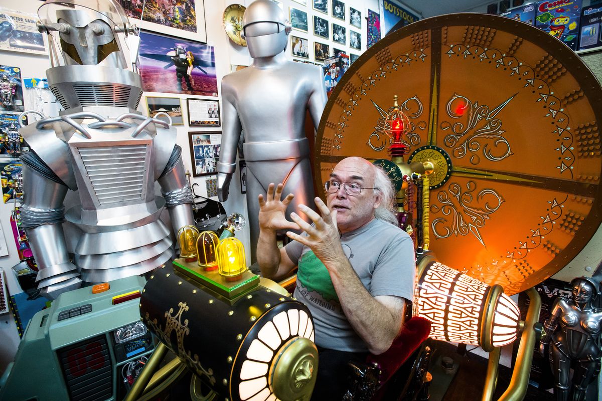 John Rigg, sitting in an H.G. Wells time machine reproduction he built, has amassed one of the largest collections of robot collectibles. (Colin Mulvany)