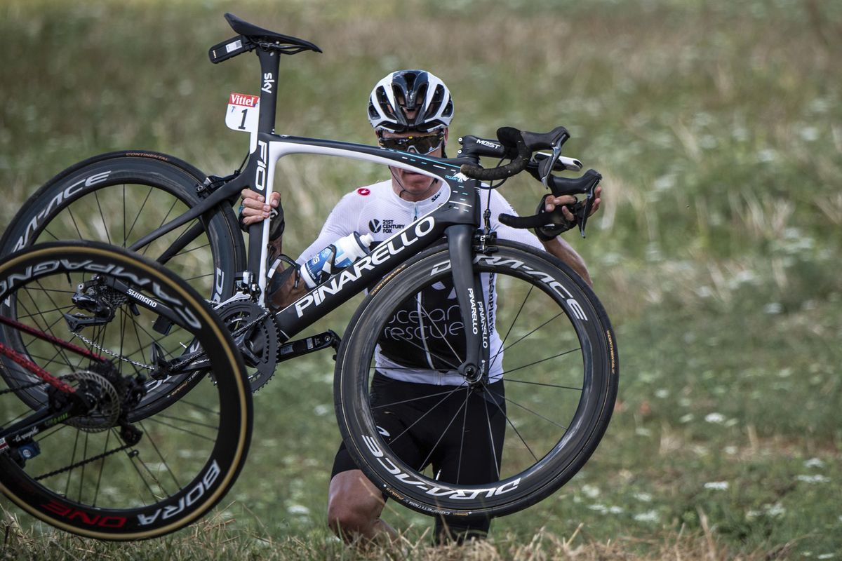 Britain’s Chris Froome carries his bicycle after falling into a ditch when crashing with other rider sduring the first stage of the Tour de France cycling race over 201 kilometers (124.9 miles) with start in Noirmoutier-en-L’Ile and finish in Fontenay Le-Comte, France, Saturday, July 7, 2018. (Jeff Pachoud / Associated Press)