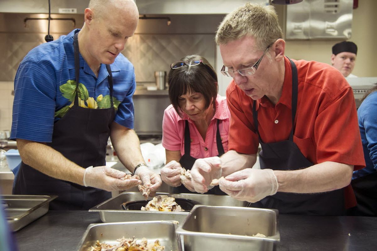 Learning to make chicken stock for soup, left to right, Craig Soehren, JoAnn Warner, and Darrell Waddell, separate chicken meat and bone during a Inland Northwest Culinary Academy