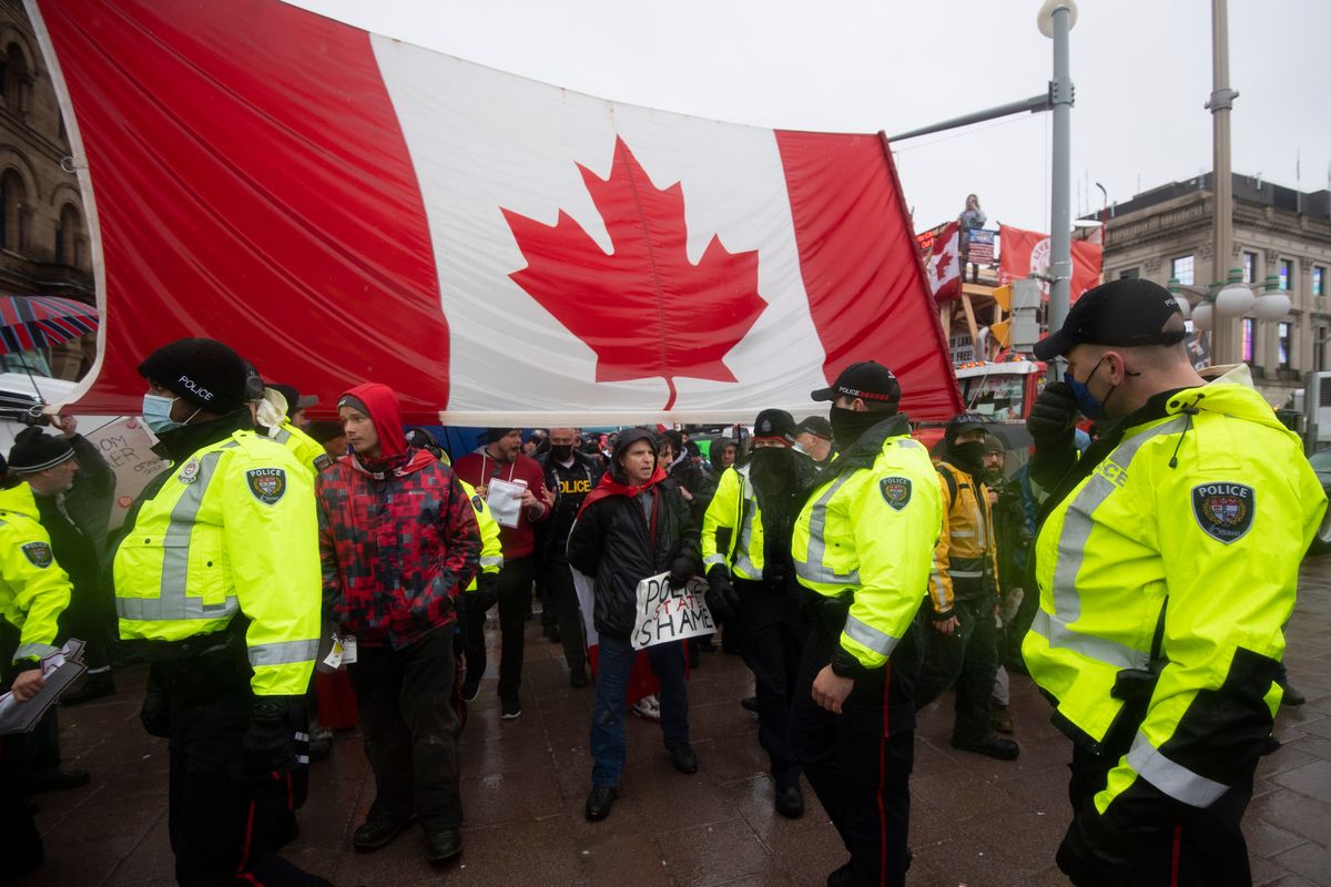 Police are followed by yelling protesters as they attempt to hand out a notices to protesters in Ottawa, on Thursday, Feb. 17, 2022. Hundreds of truckers clogging the streets of Canada