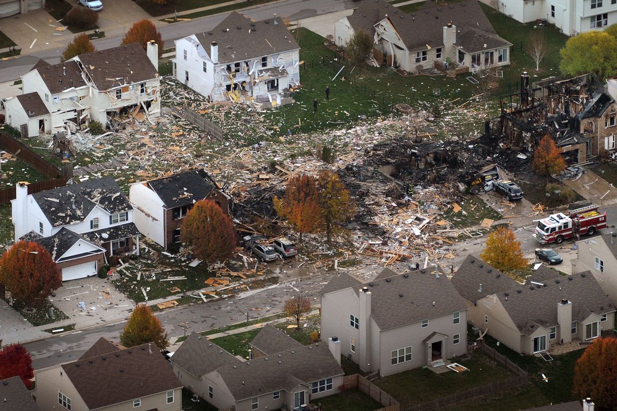 This aerial photo shows the two homes that were leveled and the numerous neighboring homes that were damaged from a massive explosion that sparked a huge fire and killed two people, Sunday, Nov. 11, 2012, in Indianapolis.  Nearly three dozen homes were damaged or destroyed, and seven people were taken to a hospital with injuries, authorities said Sunday. The powerful nighttime blast shattered windows, crumpled walls and could be felt at least three miles away. (Matt Kryger / Indianapolis Star)