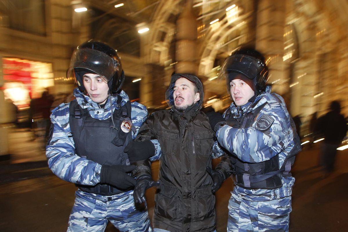 Police officers detain a protester during an unsanctioned protest in Moscow on Tuesday. (Associated Press)